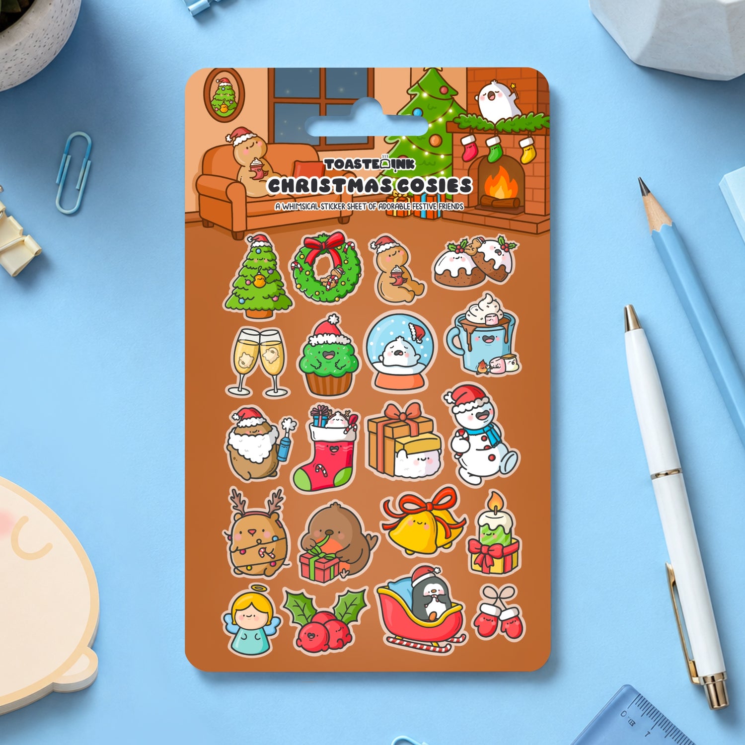 Christmas sticker sheet on blue desk with stationery scattered around