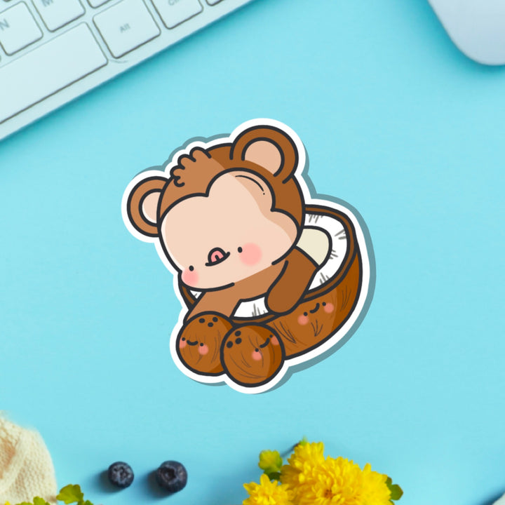 Monkey in a coconut vinyl sticker on blue table with keyboard