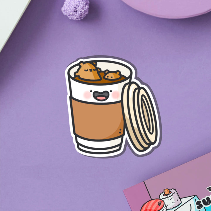 Bear in a coffee cup vinyl sticker on purple table