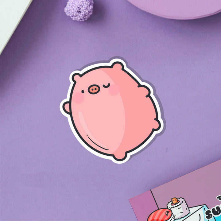 Dancing pig vinyl sticker on purple table