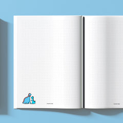 Dinosaur on dot grid page notebook on blue table
