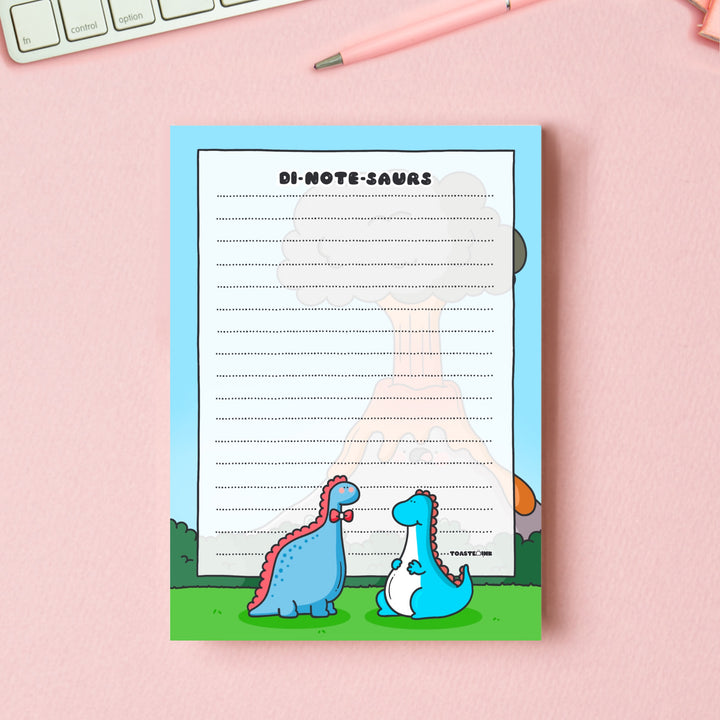 A6 Dinosaur Notepad on pink table with keyboard