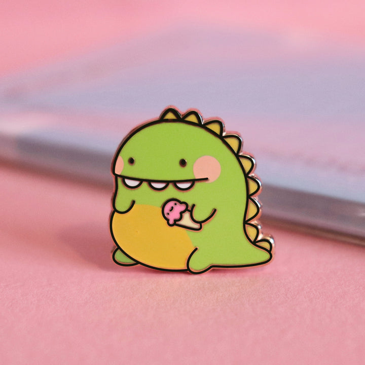 Dinosaur enamel pin on pink table