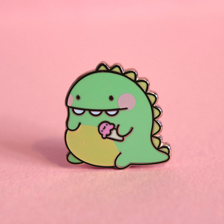 Dinosaur enamel pin on pink desk