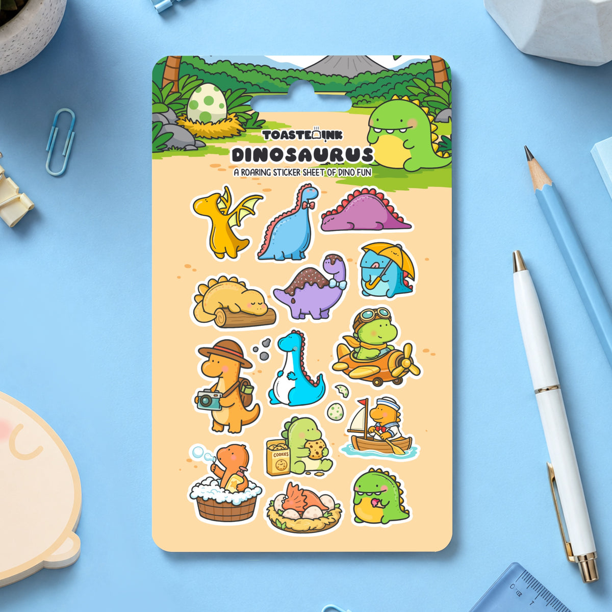 Dinosaur sticker sheet with stationery scattered around
