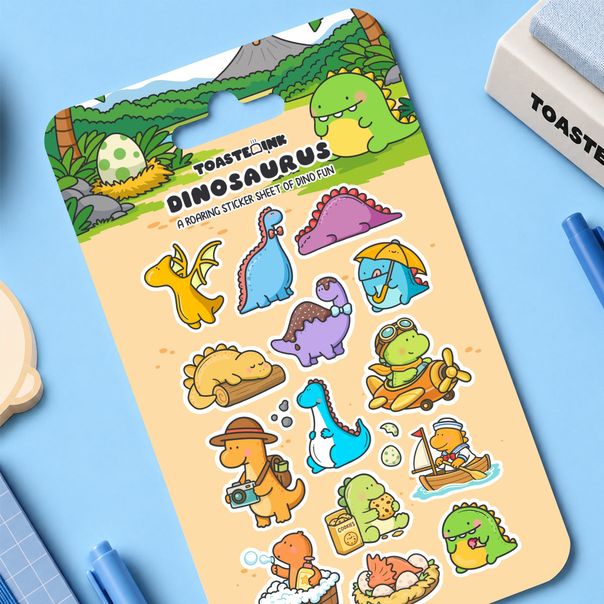 Dinosaur themed sticker sheet on blue desk with stationery