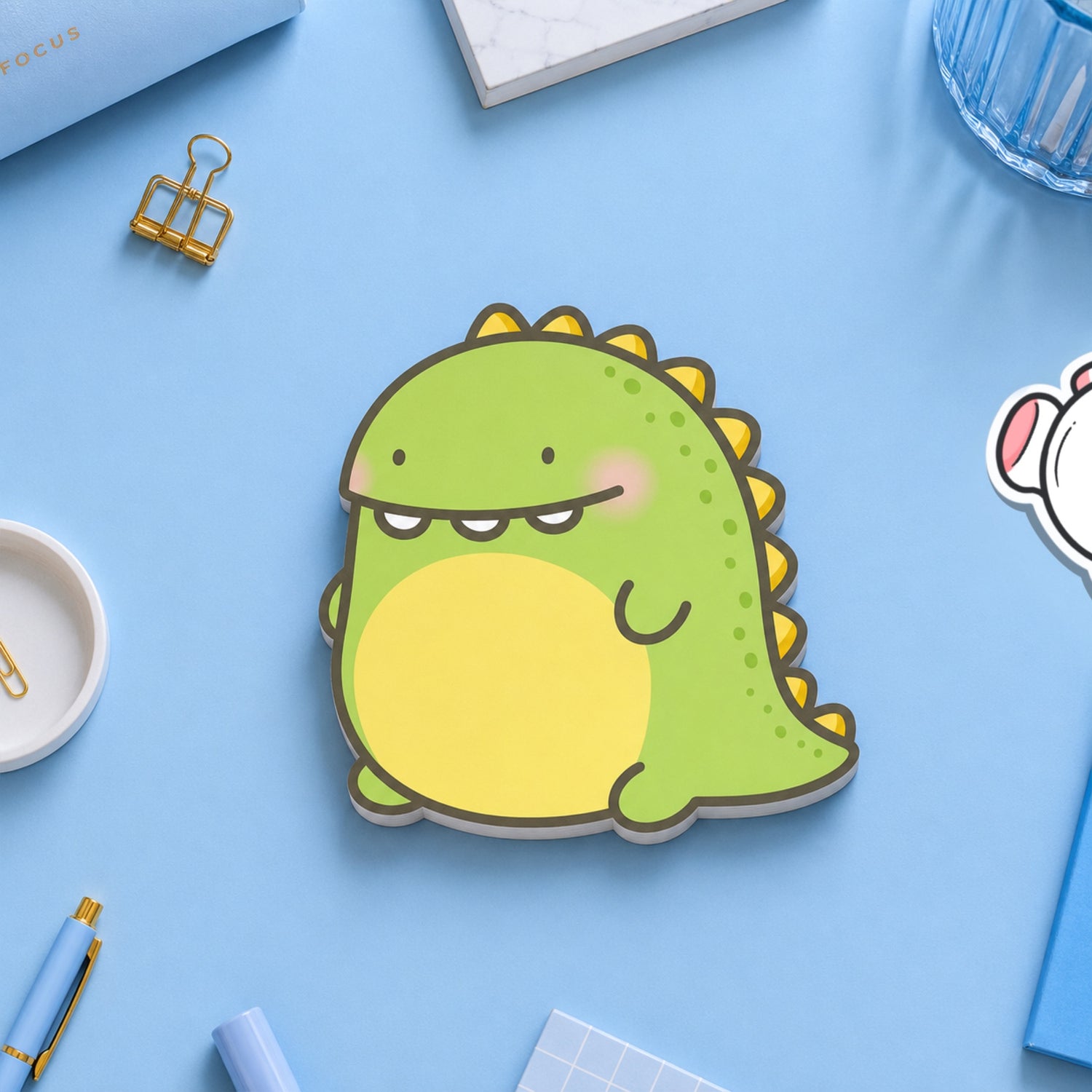 Dinosaur sticky notes on blue table with stationery