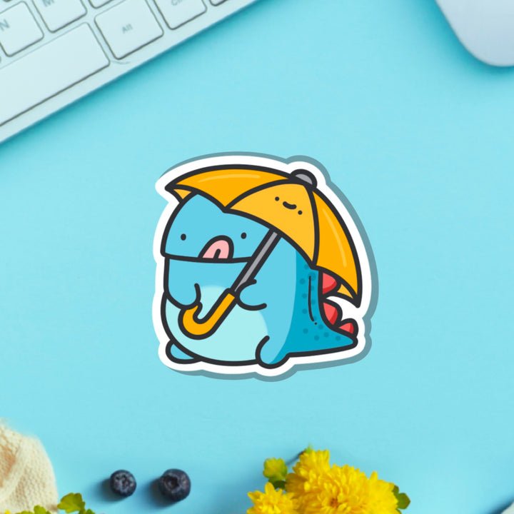 Dinosaur holding umbrella vinyl sticker on green table