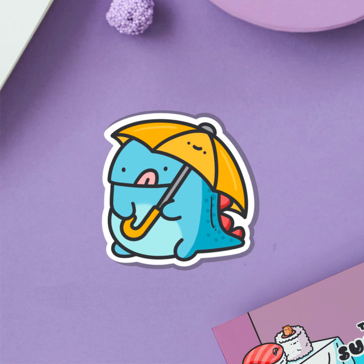 Dinosaur holding umbrella vinyl sticker on purple table