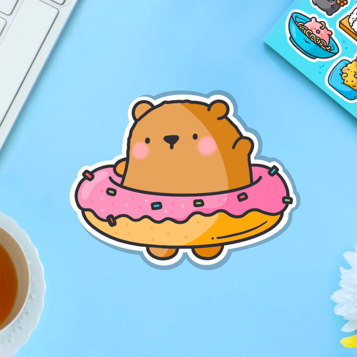 Bear in a donut vinyl sticker on blue table