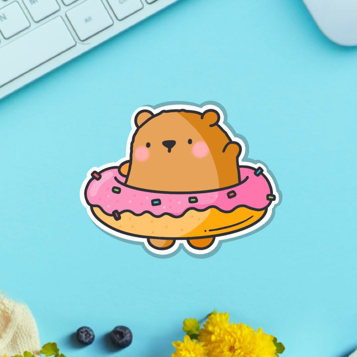 Bear in a donut vinyl sticker on blue table with keyboard