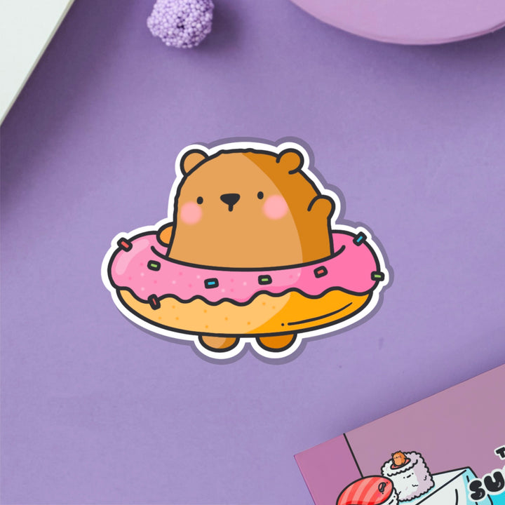 Bear in a donut vinyl sticker on purple table