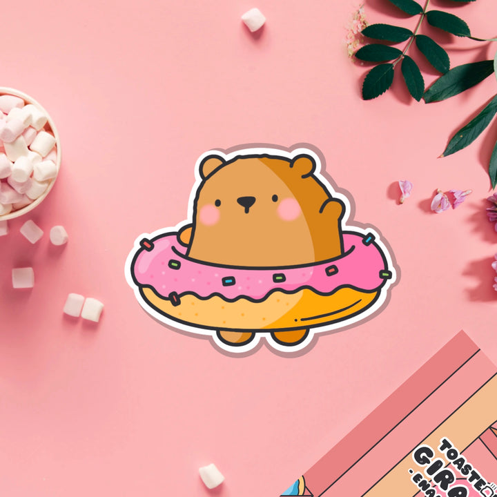 Bear in a donut vinyl sticker on pink table