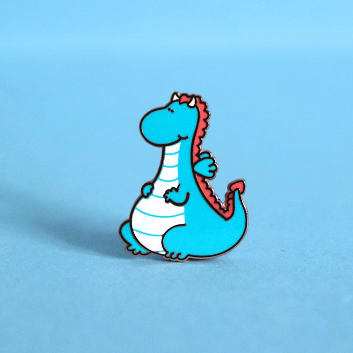 Dragon enamel pin on blue desk