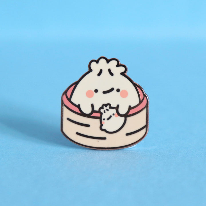 Dumpling enamel pin on blue desk