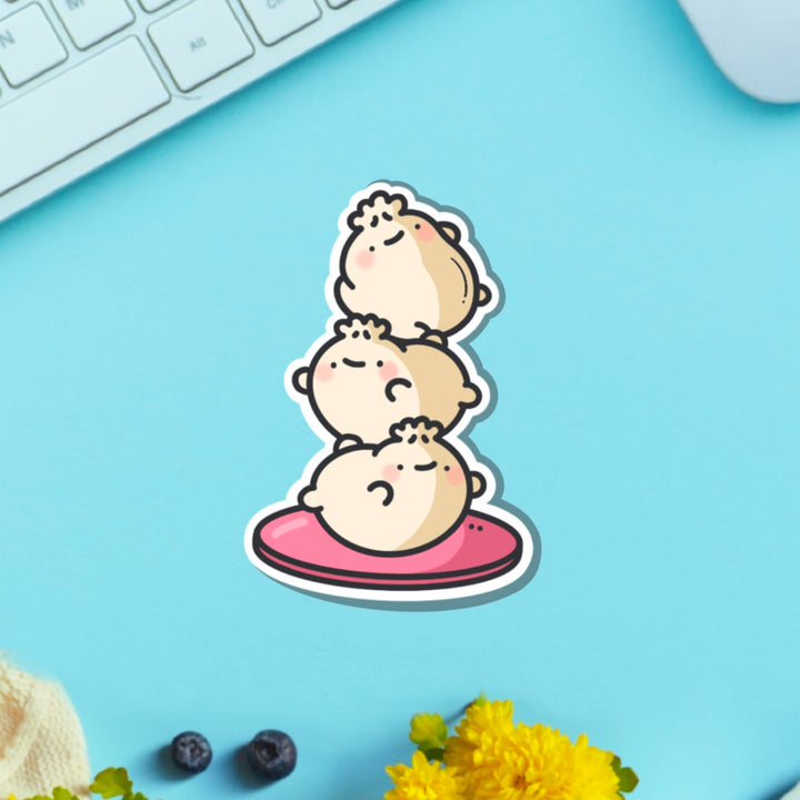 Dumpling stack vinyl sticker on blue table with keyboard