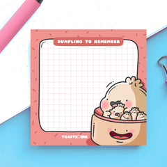 Dumpling sticky notes on blue and white table with pink pen