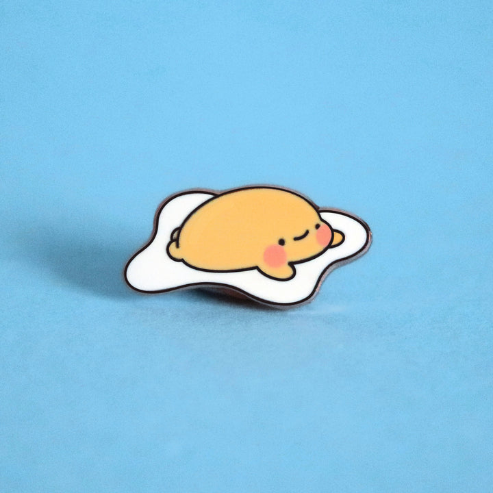 Fried egg enamel pin on blue background