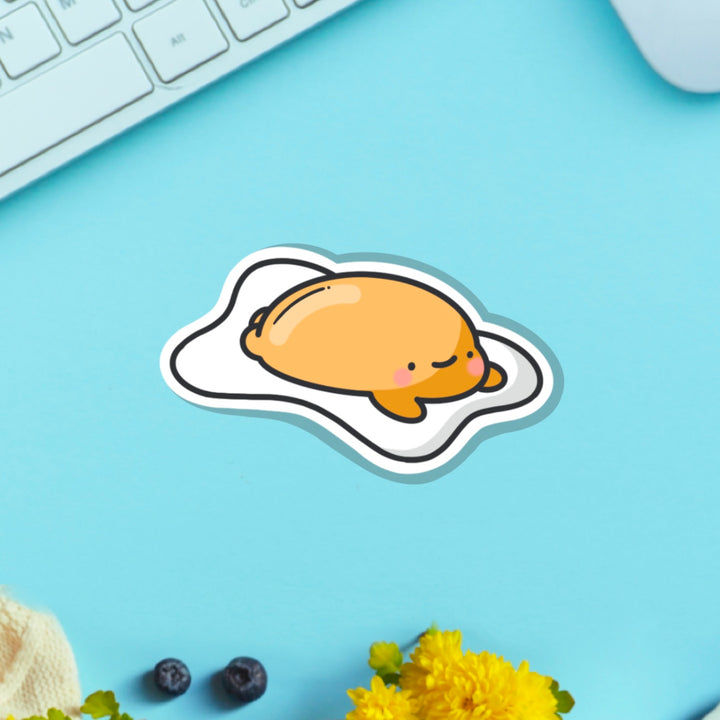 Fried egg vinyl sticker on blue table with keyboard