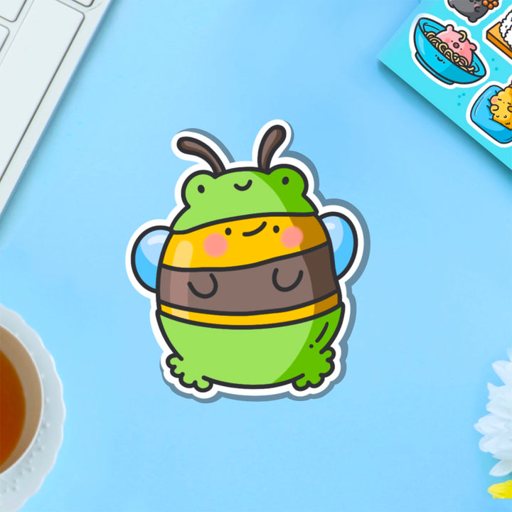 Bee dressed as frog vinyl sticker on blue table