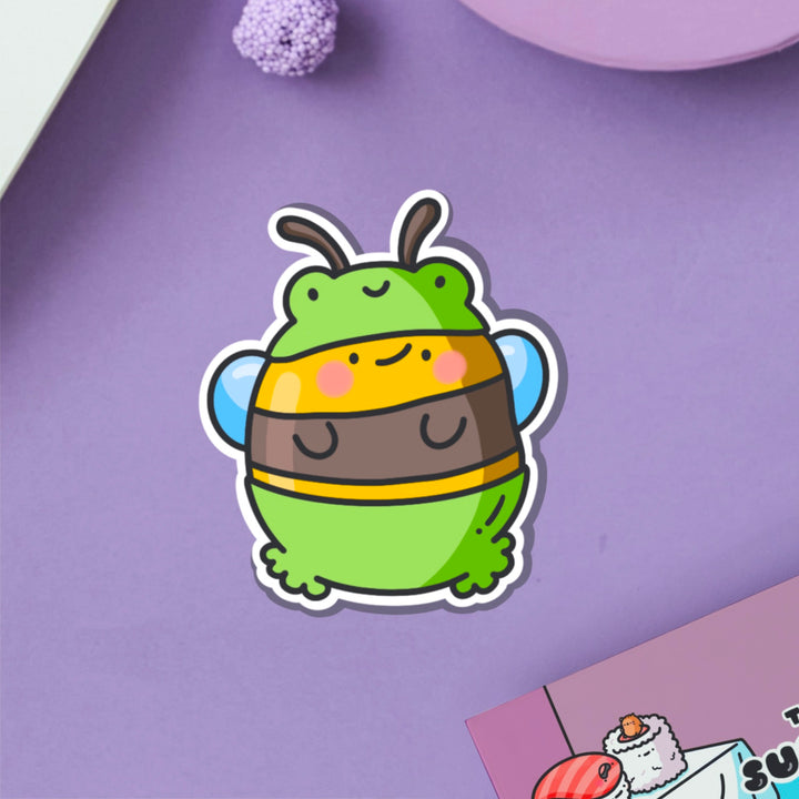 Bee dressed as frog vinyl sticker on purple table