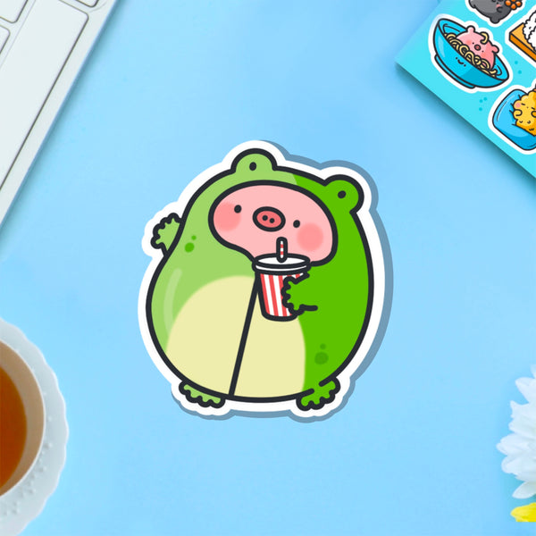 Pig in frog outfit vinyl sticker on blue table