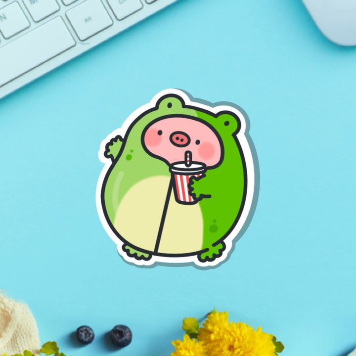 Pig in frog outfit vinyl sticker on blue table with keyboard