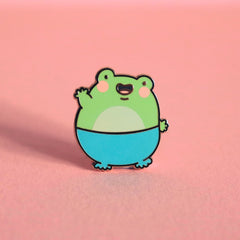 Frog enamel pin on pink table
