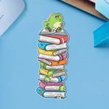 Frog sat on books bookmark on blue table