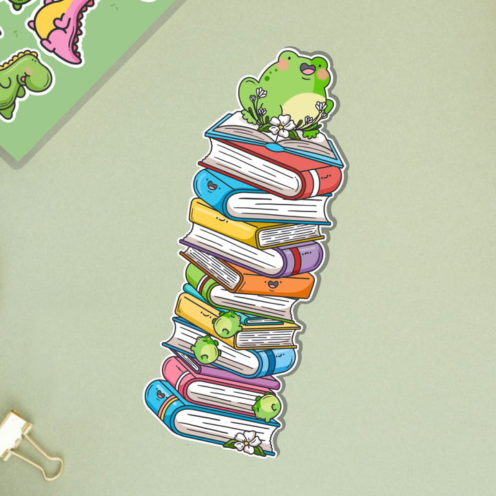 Frog sat on books bookmark on green table