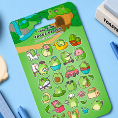 Frog sticker sheet on blue desk with notebooks and stationery