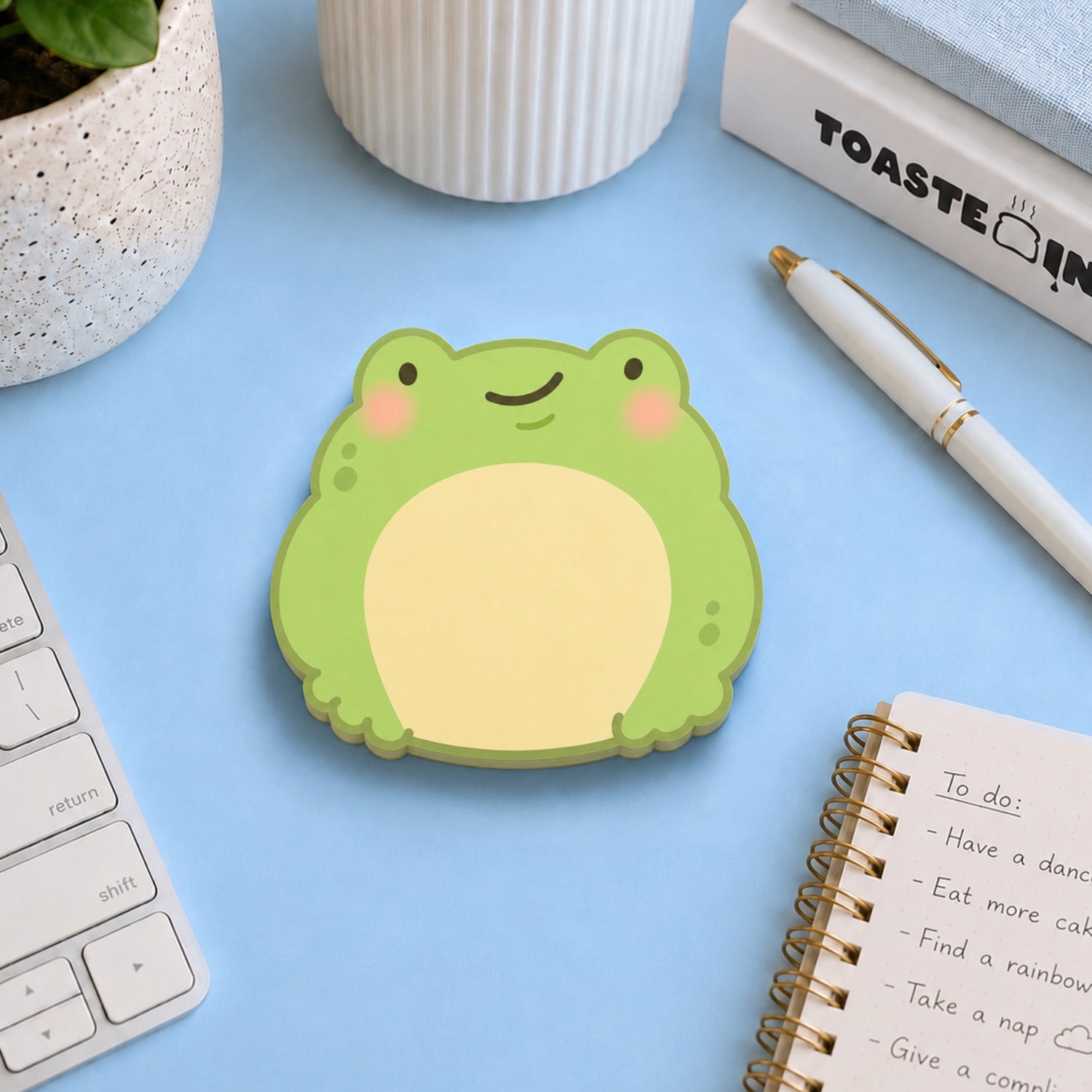 Frog shaped sticky notes on blue desk with stationery