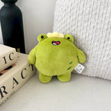 Frog Plush Keychain on beige table with books and cushion