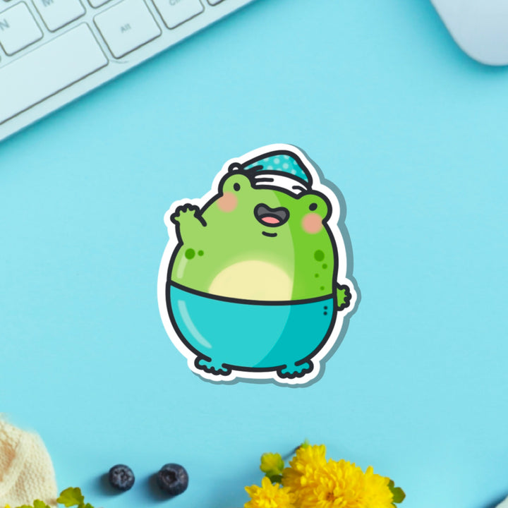 Frog in pyjamas vinyl sticker on blue table with keyboard