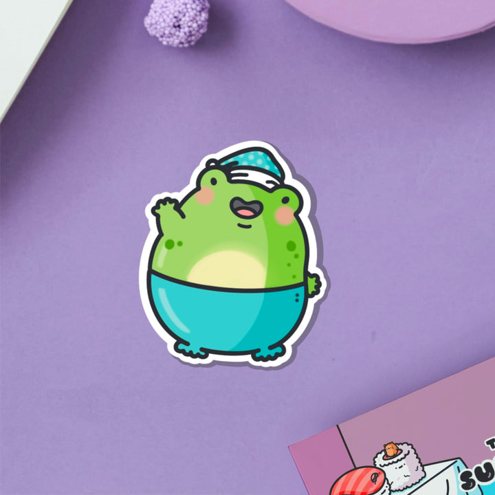 Frog in pyjamas vinyl sticker on purple table