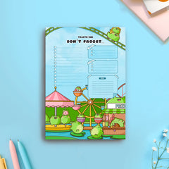 Frog theme park to do list notepad on blue table with notebooks