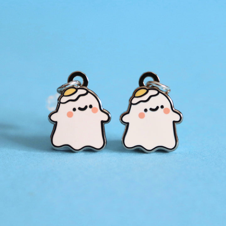 Ghost stud earrings on blue desk