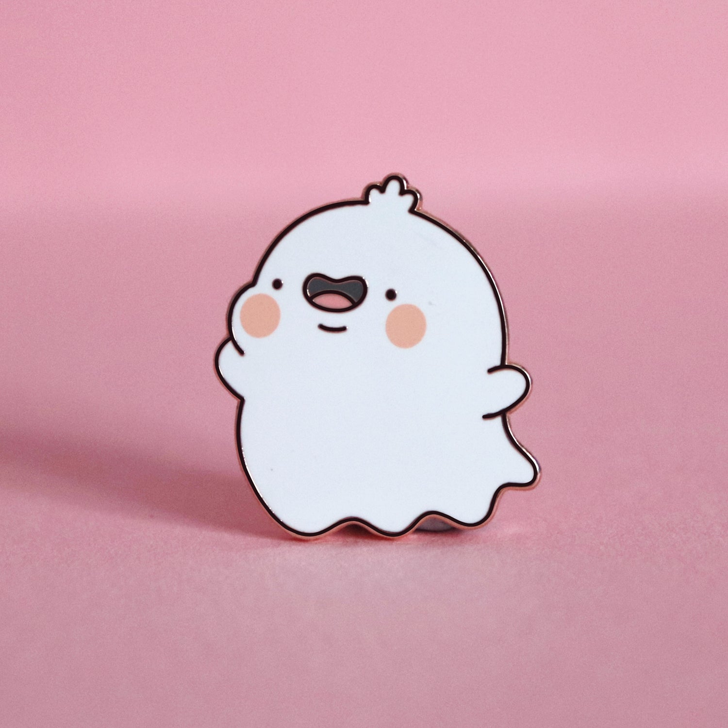 Ghost enamel pin on pink desk