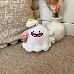 Small ghost plushie keychain with smiling fried egg and ice cream details