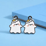 A pair of cute ghost-shaped earrings with dangle studs, featuring a white body, black outlines, pink cheeks, and a small yellow egg on his head on a light blue background.