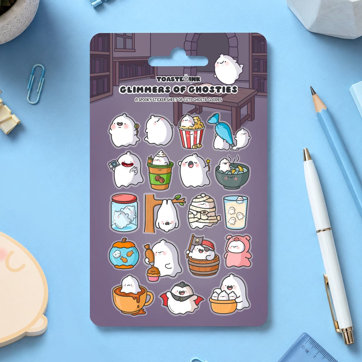 Ghost sticker sheet on blue desk with stationery scattered around