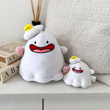Ghost plush and plush keychain on white table with cushion