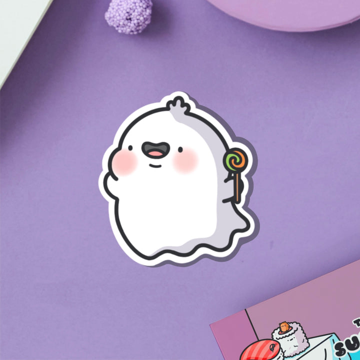 Ghost with lollipop vinyl sticker on purple table