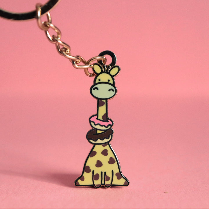 Giraffe with donuts keychain on pink table