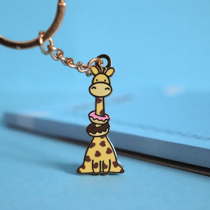 Giraffe with donuts keychain on blue table