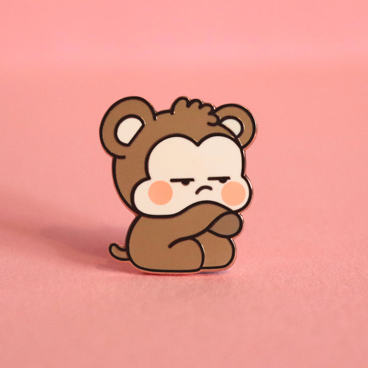 Grumpy monkey enamel pin on pink table