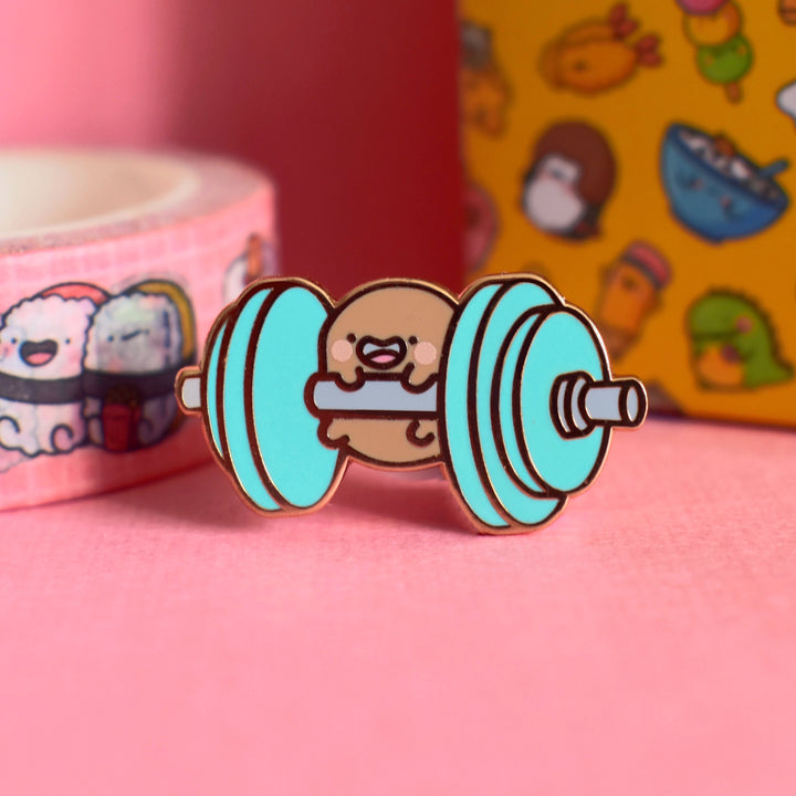 Potato lifting weights enamel pin on pink table with washi tape and box