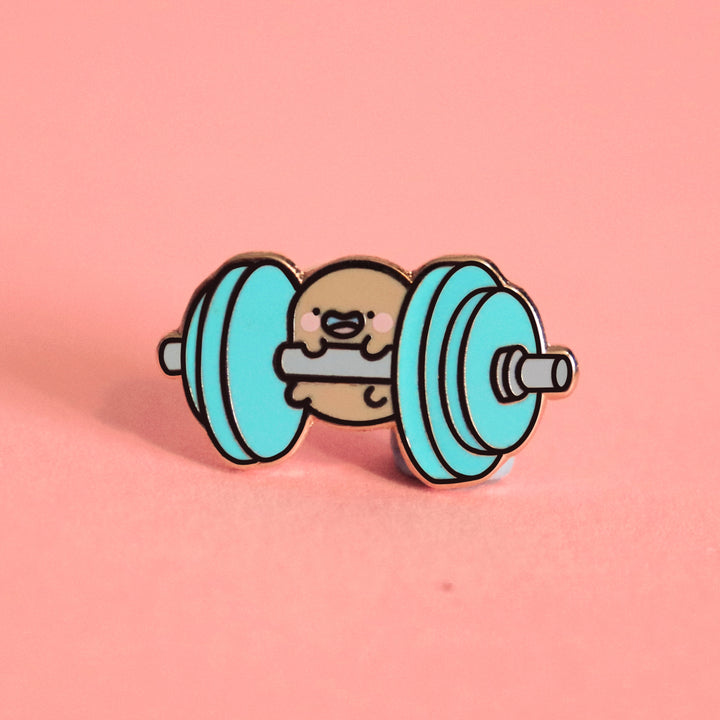 Potato lifting weights enamel pin on pink background