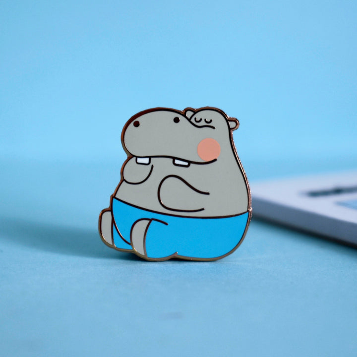 Hippo enamel pin on blue table