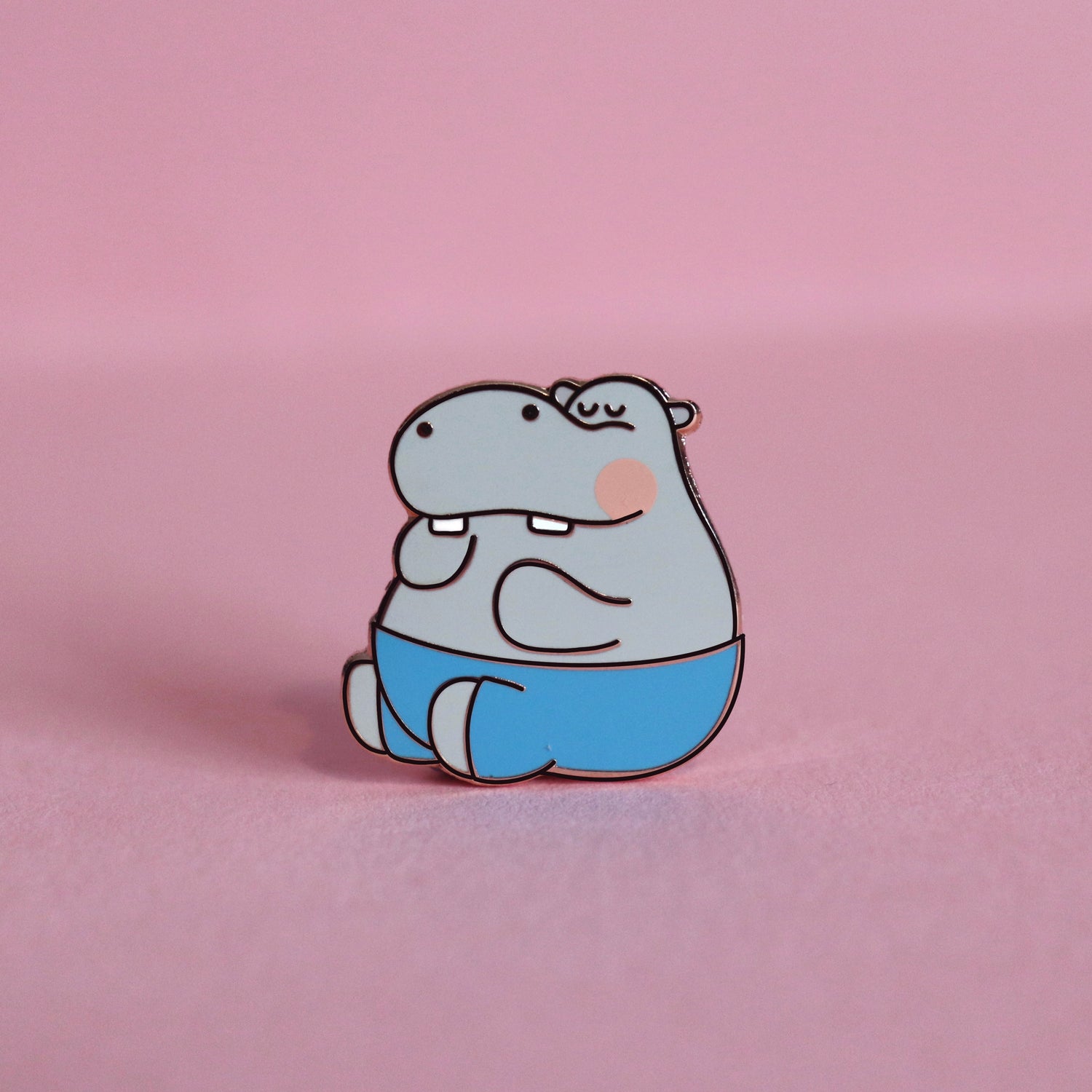 Hippo enamel pin on pink desk
